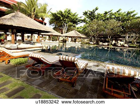 Poolside chairs around a swimming pool at a resort View Large Photo Image Stock Image - Poolside chairs around a swimming pool at a resort. Fotosearch