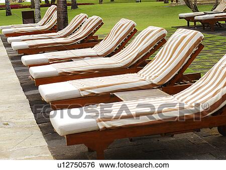 Stock Photograph - View of deck chairs arranged in a row.. Fotosearch