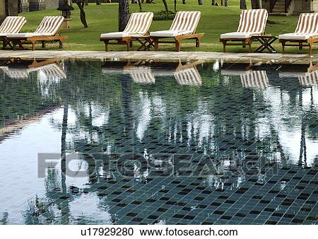View of deck chairs by a swimming pool. View Large Photo Image Stock Image - View of deck chairs by a swimming pool.. Fotosearch