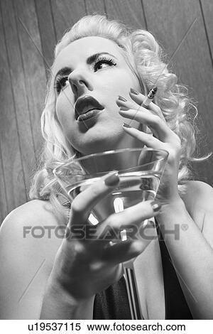 Stock Photography - Attractive Caucasian woman holding a martini and cigarette.. Fotosearch