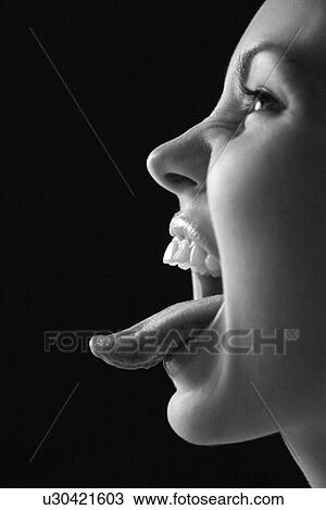 Close up profile of young woman sticking out tongue View Large Photo Image Stock Image - Close up profile of young woman sticking out tongue. Fotosearch