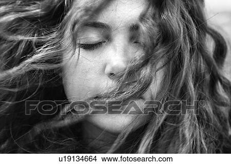 Picture - Female with hair blowing in face. Fotosearch