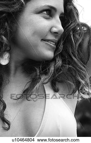 Picture - Young adult Caucasian female smiling with hair blowing.. Fotosearch