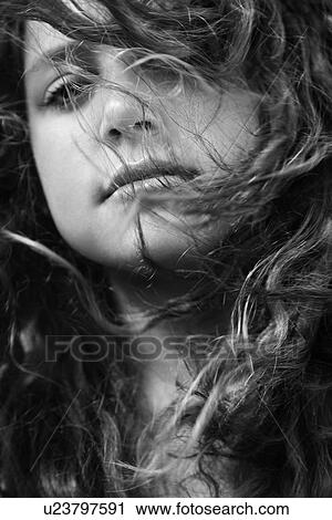 Young adult female with hair blowing in face looking at viewer View Large Photo Image Stock Image - Young adult female with hair blowing in face looking at viewer. Fotosearch