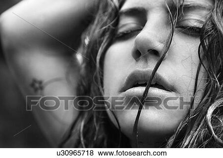 Stock Photo - Young adult woman with disheveled hair and closed eyes. Fotosearch