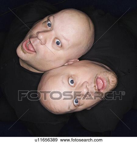 Aerial view of bald identical twin men sitting back to back making facial expressions. View Large Photo Image Stock Photo - Aerial view of bald identical twin men sitting back to back making facial expressions.. Fotosearch
