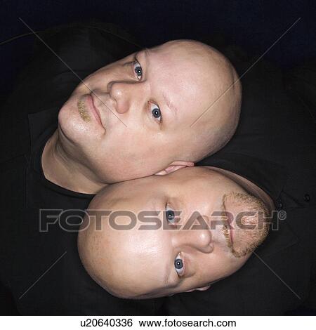 Aerial view of bald identical twin men sitting back to back and looking up at viewer View Large Photo Image Stock Photograph - Aerial view of bald identical twin men sitting back to back and looking up at viewer. Fotosearch