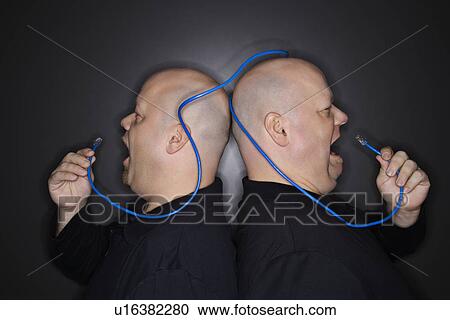 Bald identical twin men standing back to back yelling into ethernet cable View Large Photo Image Stock Image - Bald identical twin men standing back to back yelling into ethernet cable. Fotosearch