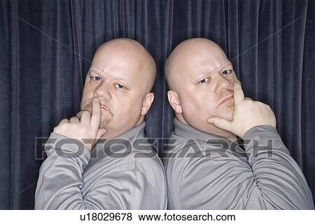 Bald identical twin men standing back to back and looking at viewer with hands to mouth. View Large Photo Image Stock Photo - Bald identical twin men standing back to back and looking at viewer with hands to mouth.. Fotosearch