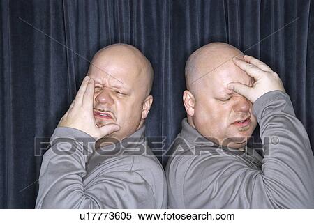 Bald identical twin men standing back to back and grimacing with hands to head View Large Photo Image Stock Photography - Bald identical twin men standing back to back and grimacing with hands to head. Fotosearch
