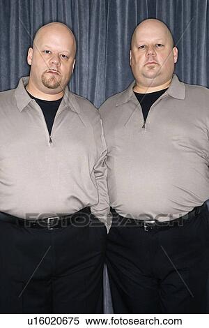 Bald identical twin mid adult men standing together looking at viewer. View Large Photo Image Stock Photography - Bald identical twin mid adult men standing together looking at viewer.. Fotosearch