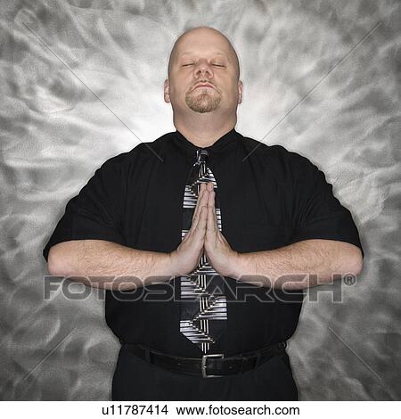 Picture - Bald man standing in a meditative position. Fotosearch
