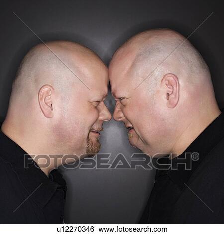 Bald mid adult identical twin men standing face to face with angry expression. View Large Photo Image Stock Photograph - Bald mid adult identical twin men standing face to face with angry expression.. Fotosearch