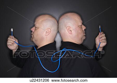 Bald mid adult identical twin men standing back to back holding ethernet cable. View Large Photo Image Stock Photograph - Bald mid adult identical twin men standing back to back holding ethernet cable.. Fotosearch