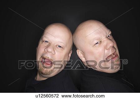 Identical twin men standing back to back with sad expressions View Large Photo Image Stock Image - Identical twin men standing back to back with sad expressions. Fotosearch
