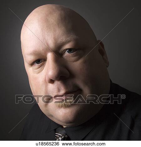 Stock Photograph - Mid adult bald man looking at viewer.. Fotosearch