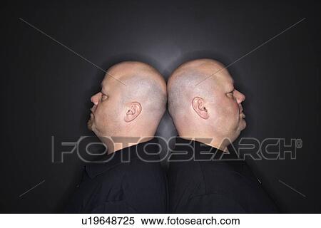 Mid adult identical twin bald men standing back to back. View Large Photo Image Stock Photography - Mid adult identical twin bald men standing back to back.. Fotosearch