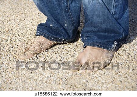 Male feet in jeans on sandy beach View Large Photo Image Stock Image - Male feet in jeans on sandy beach. Fotosearch