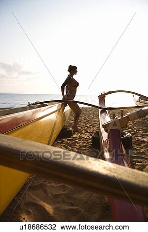 Silhouette of sexy woman in bikini beside outrigger canoe on beach View Large Photo Image Stock Image - Silhouette of sexy woman in bikini beside outrigger canoe on beach . Fotosearch