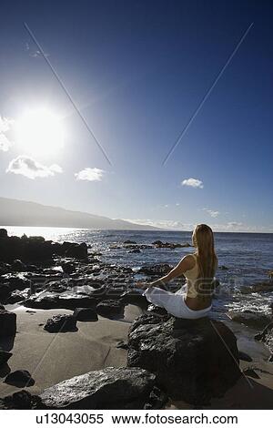 Young adult Asian Filipino female meditating on rocky beach View Large Photo Image Stock Photography - Young adult Asian Filipino female meditating on rocky beach . Fotosearch