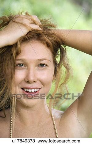 Beautiful woman holding hair up while smiling and looking at viewer. View Large Photo Image Stock Photo - Beautiful woman holding hair up while smiling and looking at viewer.. Fotosearch