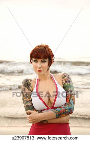 Stock Image - Attractive tattooed woman on beach . Fotosearch