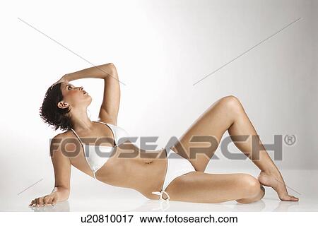 Caucasian young adult woman in bikini reclining and looking up. View Large Photo Image Stock Photo - Caucasian young adult woman in bikini reclining and looking up.. Fotosearch
