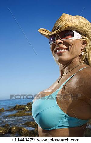 Stock Photo - Close up of pretty Caucasian mid adult woman bodybuilder in bikini on beach.. Fotosearch