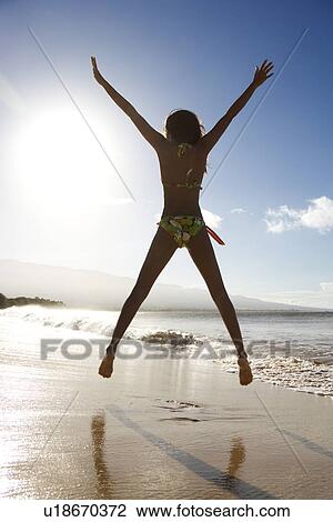 Girl in bikini jumping on beach View Large Photo Image Stock Image - Girl in bikini jumping on beach . Fotosearch