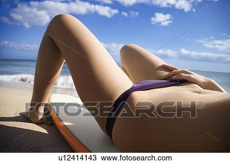 Woman in bikini lying on surfboard View Large Photo Image Stock Image - Woman in bikini lying on surfboard . Fotosearch