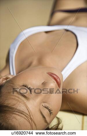 Picture - Woman in bikini sunbathing at beach . Fotosearch
