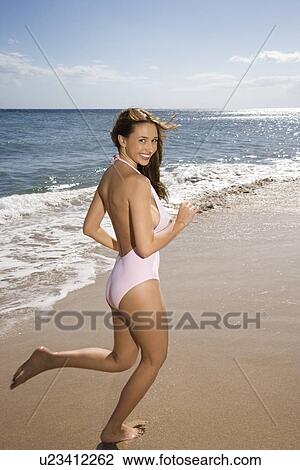 Woman in swimsuit running on beach View Large Photo Image Stock Image - Woman in swimsuit running on beach . Fotosearch