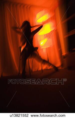 Blurred pretty young woman silhouetted by floor lamp View Large Photo Image Stock Image - Blurred pretty young woman silhouetted by floor lamp. Fotosearch