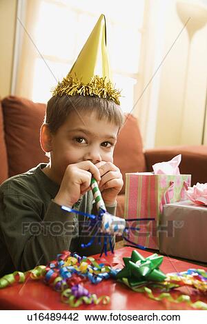 Boy at birthday party looking at viewer blowing noisemaker View Large Photo Image Stock Image - Boy at birthday party looking at viewer blowing noisemaker. Fotosearch