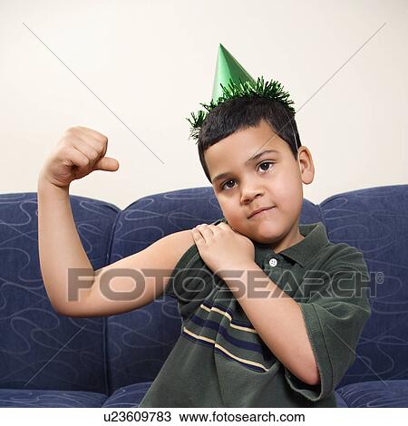 Boy wearing party hat playfully flexing arm muscle while looking at viewer View Large Photo Image Stock Image - Boy wearing party hat playfully flexing arm muscle while looking at viewer. Fotosearch