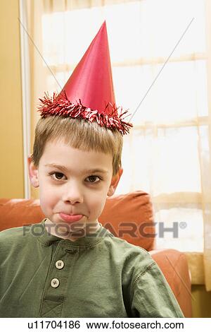 Boy wearing party hat pouting and looking at viewer View Large Photo Image Stock Photograph - Boy wearing party hat pouting and looking at viewer. Fotosearch