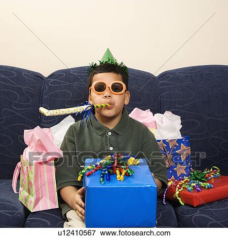 Stock Photo - Boy with birthday party favors and presents looking at viewer. Fotosearch