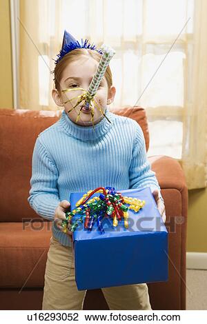 Caucasian girl blowing noisemaker and holding gift. View Large Photo Image Stock Image - Caucasian girl blowing noisemaker and holding gift.. Fotosearch