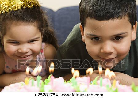 Picture - Girl and boy looking at lit candles . Fotosearch