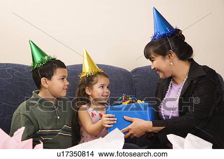 Mother giving present to daughter at birthday party. View Large Photo Image Picture - Mother giving present to daughter at birthday party.. Fotosearch