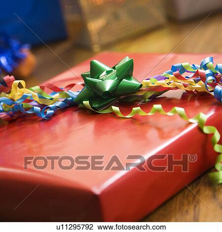 Stock Image - Presents wrapped and decorated with bows on a table.. Fotosearch