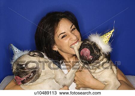 Stock Image - Female holding Pug dogs. Fotosearch