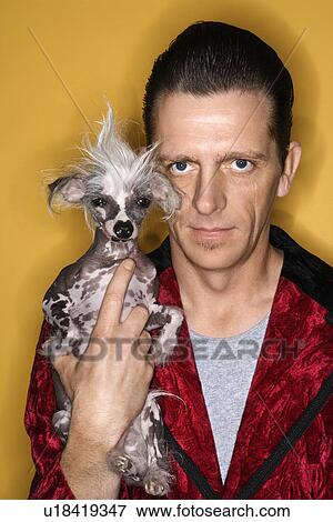 Stock Photo - Male wearing velvet and holding Chinese Crested dog. Fotosearch