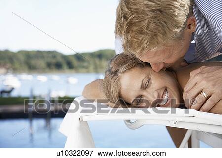 Couple embracing on lounge chair View Large Photo Image Stock Photo - Couple embracing on lounge chair. Fotosearch