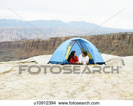 Picture - Couple in tent, rock strata in background, Moab, Utah, USA. Fotosearch