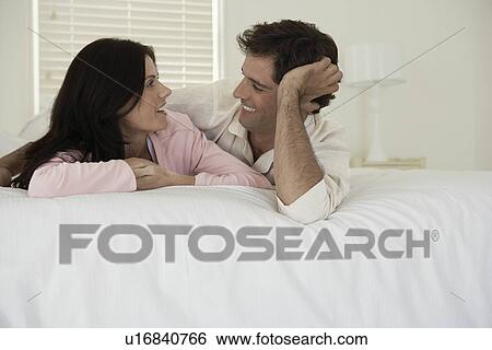 Stock Photograph - Couple lying on bed. Fotosearch