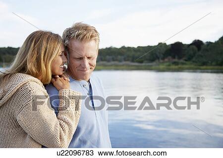 Couple standing by lake View Large Photo Image Stock Image - Couple standing by lake. Fotosearch