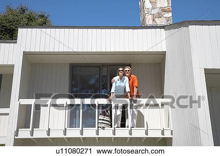 Couple standing on balcony View Large Photo Image Stock Image - Couple standing on balcony. Fotosearch