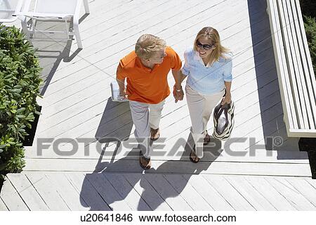 Couple with luggage walking up steps (high angle view) View Large Photo Image Stock Photograph - Couple with luggage walking up steps (high angle view). Fotosearch