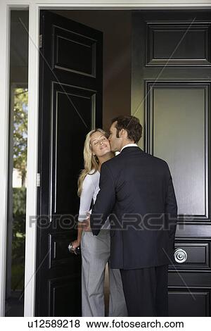 Stock Photo - Husband kissing wife before leaving for work. Fotosearch